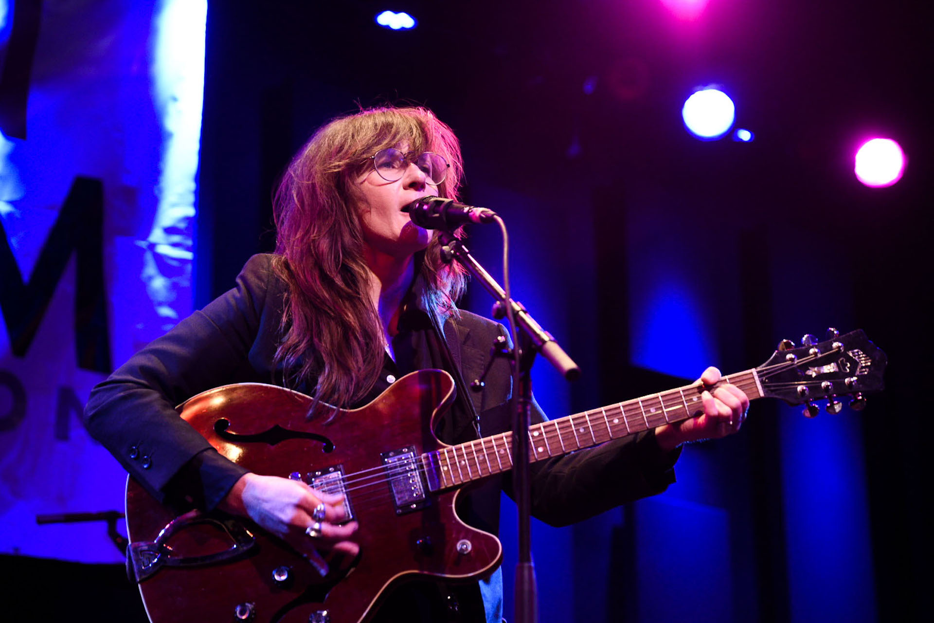 woman playing guitar on stage