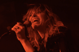 Ruby The Hatchet rages under red lights in the concert-shot music video for “The Change”
