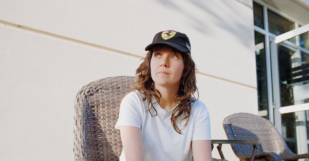 Courtney sitting in a chair, looking away.